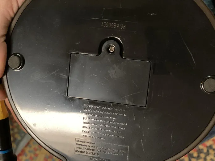 The underside of a kids’ toy showing a battery door held shut by a single Phillips screw.